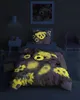 A child's bedroom with a bed made up with a teddy bear themed duvet cover and pillow. The room is dimly lit, and the duvet cover and pillow have glow-in-the-dark elements that are illuminated. Produktbild-Vorschau
