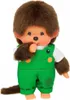 A Monchhichi doll wearing green overalls and a white shirt, with its thumb in its mouth. Náhled obrázku produktu