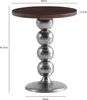 A product shot of a round side table with a wooden top and a metallic base made of stacked spheres. Voir les images du produit