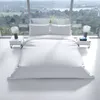 A white duvet set on a bed in a modern room with a large window overlooking a landscape. Produktbild-Vorschau