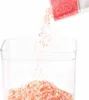 Pink salt being poured from a packet into a clear rectangular container. Náhľad obrázku produktu