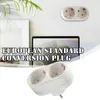 A white electrical adapter with two sockets is shown against a white background, with a laptop and some greenery in the background. Text overlay describes the product. Produktbild-Vorschau