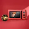 A red microwave oven is shown with a circular inset image of lasagna. Podgląd zdjęcia produktu