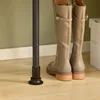 Fußplatte und Stiefel neben dem schwarzen SoBuy Garderobenständer Voir les images du produit