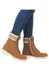 A pair of brown lace-up boots worn by a person wearing blue jeans. Produktbild-Vorschau