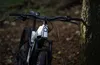 A close-up shot of an electric mountain bike leaning against a tree in a forest. Produktbild-Vorschau