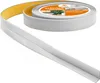 A roll of self-adhesive flexible skirting board is partially unrolled, showing the adhesive backing. Náhled obrázku produktu