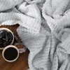 A cozy scene with a grey blanket, a cup of coffee, and chocolates. Náhled obrázku produktu