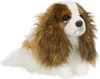A plush toy dog is lying down on a white background. Produktbild-Vorschau