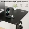 A black desk with a wireless charging stand holding a phone and a smartwatch, a laptop, a plant, and a headphone hook with headphones. Produktbild-Vorschau