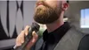 A man is trimming his beard with an electric trimmer. Produktbild-Vorschau