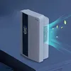 A white dehumidifier with a digital display is shown on a dark surface, with blue air currents and yellow leaves emanating from its side. Náhled obrázku produktu