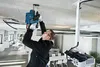 A man is installing a projector on the ceiling in an office space. Produktbild-Vorschau