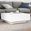 A white coffee table with a plant and a cup of coffee on it, placed in front of a gray sofa. Náhľad obrázku produktu