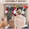 A woman and a child are sitting in front of a fireplace decorated with Christmas stockings. Náhľad obrázku produktu