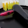 A close-up of a hairdryer and several small tubes of toiletries. Produktbild-Vorschau