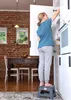 A young girl stands on a stool reaching into a kitchen cabinet. Náhled obrázku produktu