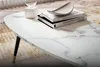A close-up of a marble-look coffee table with books and a decorative bowl on it, placed on a rug. Voir les images du produit