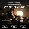 A man sitting in a private jet, looking at a power bank. Produktbild-Vorschau