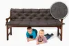 Two young children are lying under a dark gray bench cushion on a wooden bench. Produktbild-Vorschau