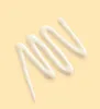 A wavy line of white cream on a light yellow background. Produktbild-Vorschau
