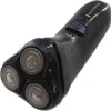 A black electric shaver with three rotary heads is shown from a diagonal angle against a white background. Voir les images du produit