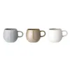 Three ceramic mugs in different colors are displayed against a white background. Produktbild-Vorschau