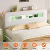 A bed with a headboard featuring shelves and LED lighting, with decorative items and a blanket. Produktbild-Vorschau