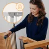 A woman is shown interacting with a baby gate, possibly installing or operating it. Voir les images du produit