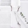 A close-up view of a transparent curtain with a branch and leaf pattern, with a clear plastic tube or rod inserted through a loop at the top. A small sprig of eucalyptus in a glass vial is visible in the background. Produktbild-Vorschau