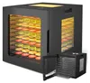 A black food dehydrator with multiple trays filled with sliced fruits and vegetables, shown from a slightly angled front view. A smaller, open version of the dehydrator is placed in the foreground. Produktbild-Vorschau