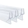 Three clear plastic shower door seals are arranged diagonally on a white background. Voir les images du produit