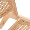 A close-up view of the wooden frame and rattan weave of a chair. Náhľad obrázku produktu