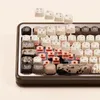 A close-up, angled view of a mechanical keyboard with a wooden frame and cream-colored keycaps, some of which are decorated with artistic designs. Produktbild-Vorschau