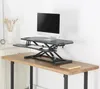 A standing desk converter is placed on a wooden desk, with a computer, keyboard, and mouse on it. Anteprima dell’immagine prodotto