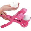 A hand holding a smiley-face snowball above a pink snowball maker. Náhled obrázku produktu