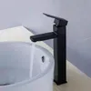 A black faucet is installed on a white sink, with water running. Podgląd zdjęcia produktu