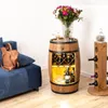 A living room scene featuring a barrel-shaped wine cabinet, a blue sofa with a tan backpack, and a wooden wine rack. Náhled obrázku produktu