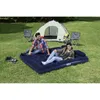 A couple is relaxing on an inflatable air mattress outdoors, in front of a tent with camping chairs nearby. Anteprima dell’immagine prodotto