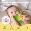 A baby is holding and chewing on a plush corn toy. Produktbild-Vorschau