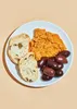 A plate of food with bread, olives, and a spread. Produktbild-Vorschau