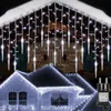 Icicle lights are decorating the roofline of a house at night. Produktbild-Vorschau