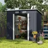 A dark gray garden shed is shown in a grassy yard with plants and gardening tools. Produktbild-Vorschau