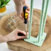 A person is screwing a hairpin leg onto a wooden surface. Produktbild-Vorschau