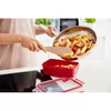 A person is transferring pasta from a frying pan into a red food storage container. Anteprima dell’immagine prodotto