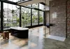 A modern bathroom with a freestanding black bathtub and a glass-enclosed shower, set against a backdrop of large windows overlooking a natural landscape. Anteprima dell’immagine prodotto