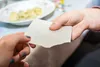 Two people are exchanging a piece of white paper. Produktbild-Vorschau
