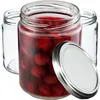 Three glass jars, one filled with red cherries in liquid, and a silver lid resting next to it. Two empty jars are visible in the background. Produktbild-Vorschau