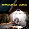 A person is interacting with a bicycle in front of a garage door, illuminated by a solar-powered garden light. Produktbild-Vorschau