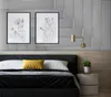 A bedroom scene with a bed, wall art, and a nightstand. Podgląd zdjęcia produktu